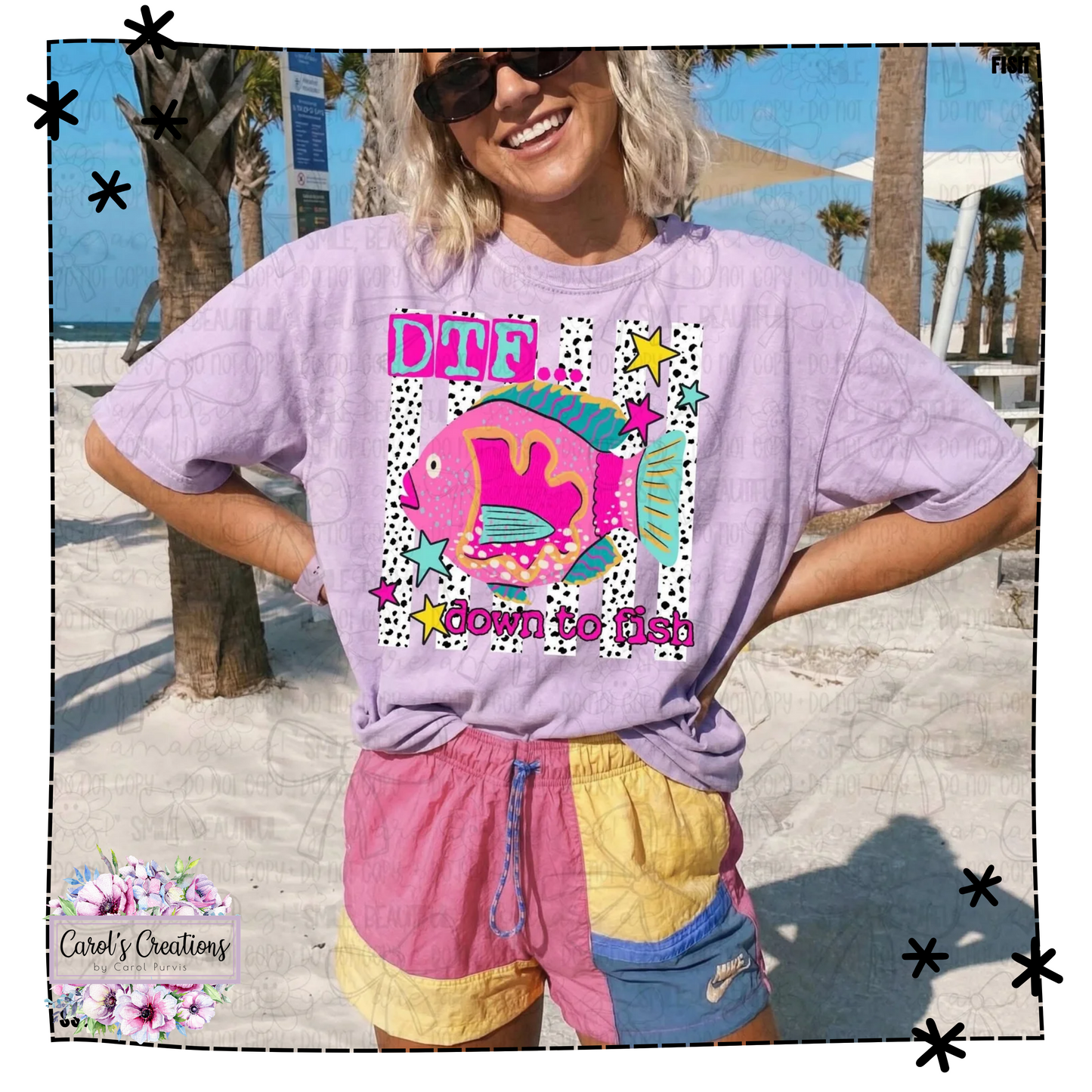 Person wearing a purple t-shirt with a colorful graphic and text, standing on a beach.