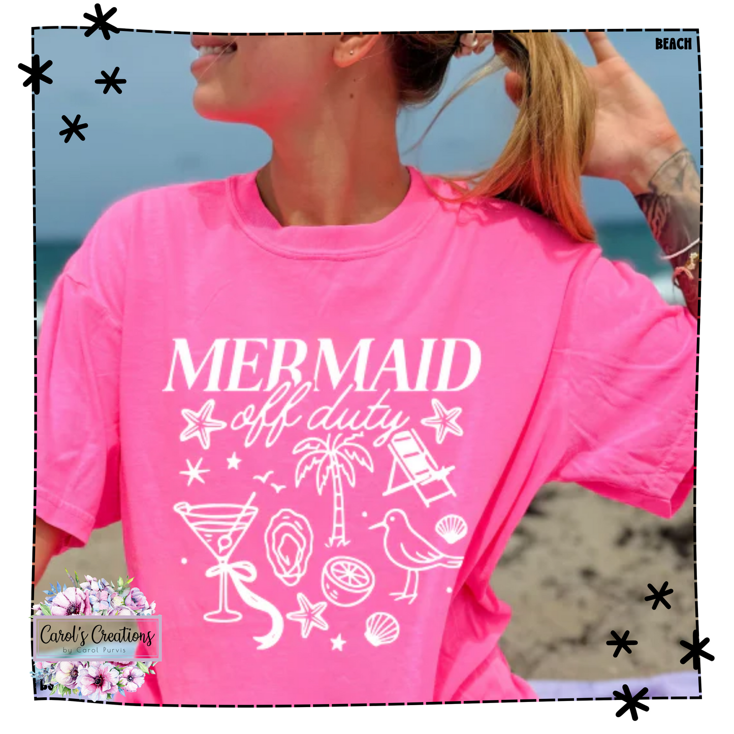 Person wearing a pink t-shirt with 'Mermaid off duty' design on a beach.