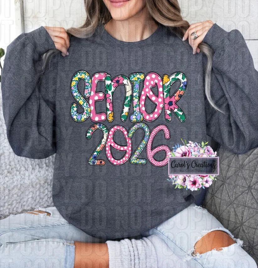 Person wearing a gray sweatshirt with 'Senior 2026' text in colorful letters.