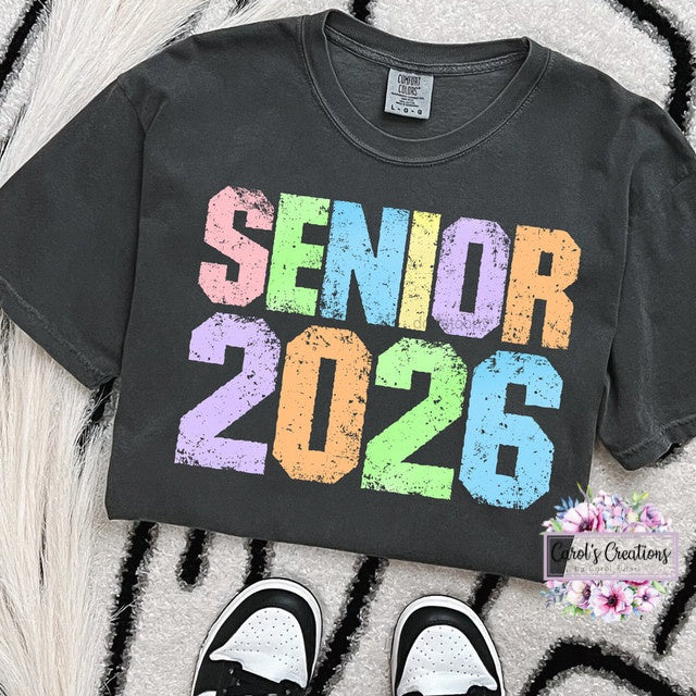 Black t-shirt with 'Senior 2026' text in colorful letters on a textured surface.